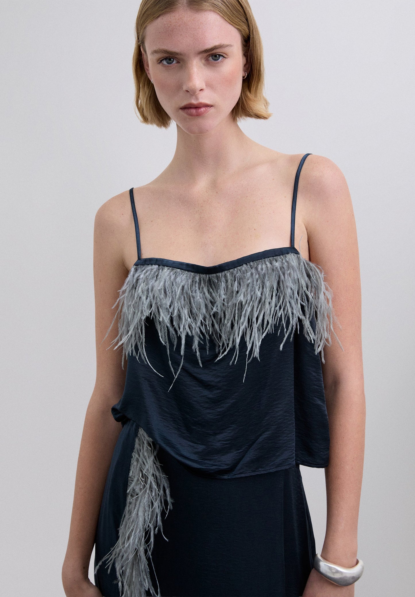 SATIN TOP WITH FEATHER DETAILS.